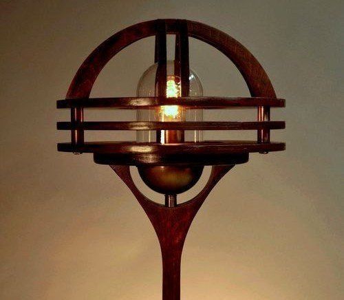 Art Deco-style lamp with a glowing bulb and dark metal frame against a warm beige background