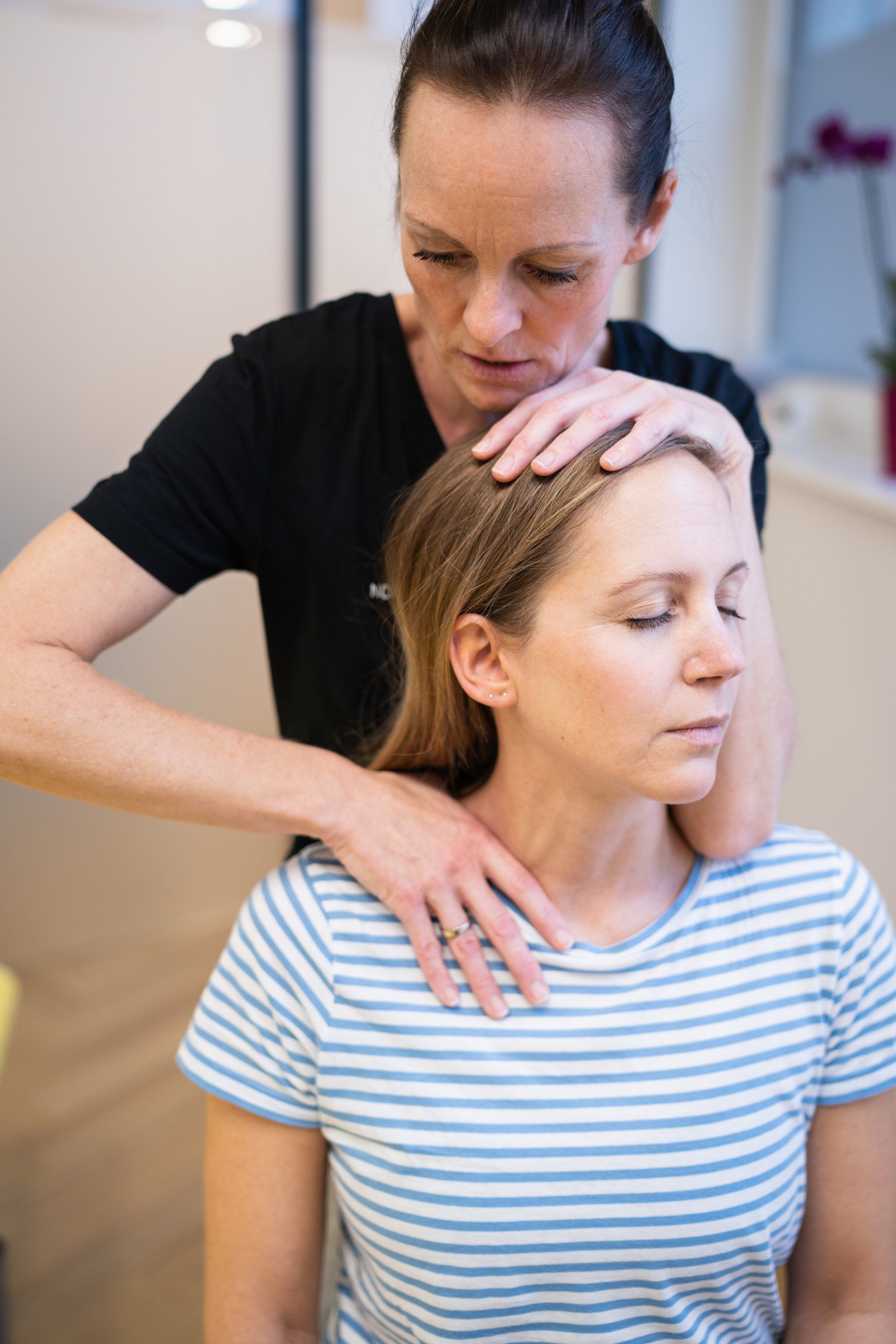Eine Frau im gestreiften Hemd bei der Physiotherapie.