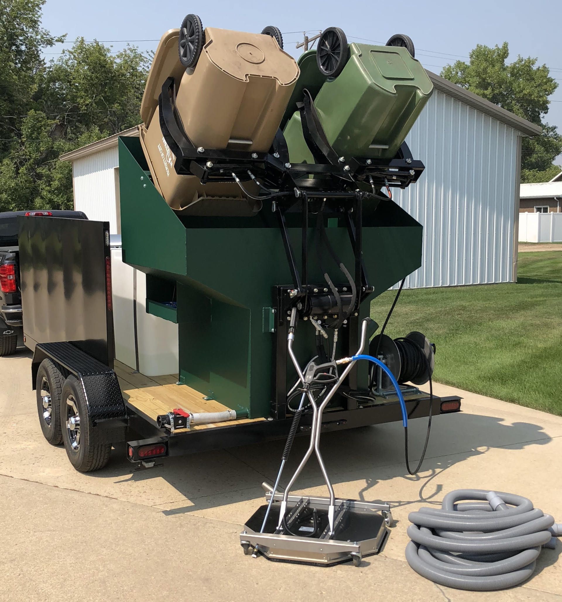 2 Bin Hopper loading trash cans over spray heads with pressure washer