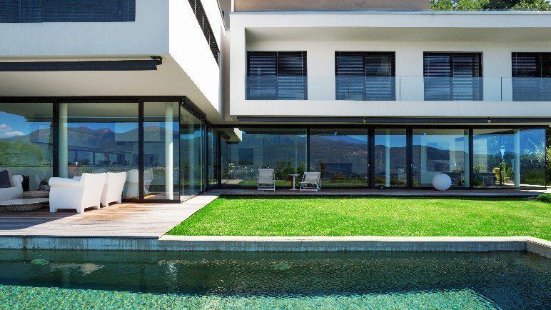 Ein modernes Haus mit einem großen Swimmingpool davor.