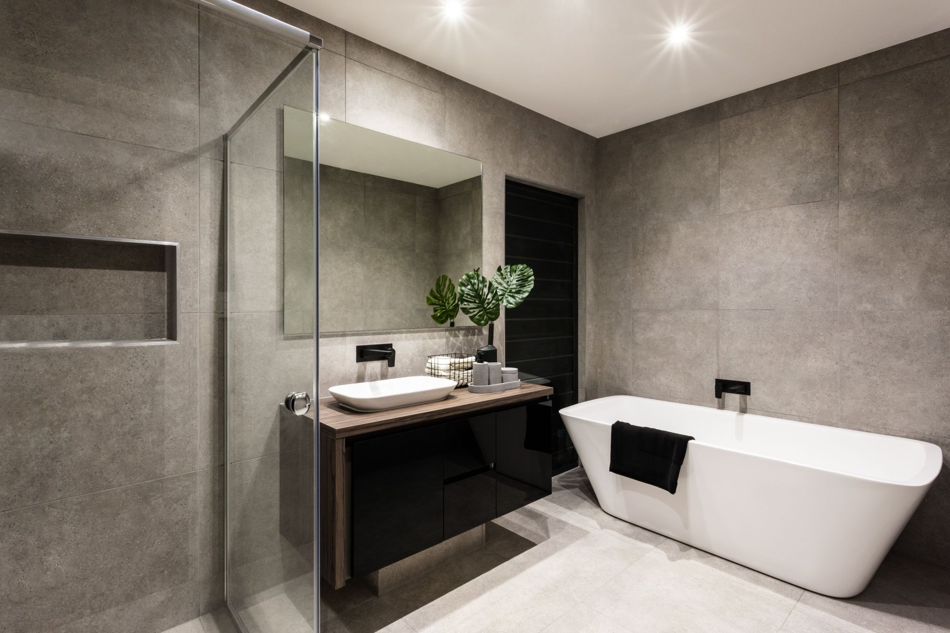 Ein Badezimmer mit Badewanne, Waschbecken, Spiegel und ebenerdiger Dusche.