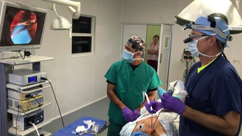 Zwei Chirurgen führen in einem Krankenzimmer eine Operation unter Überwachung durch.