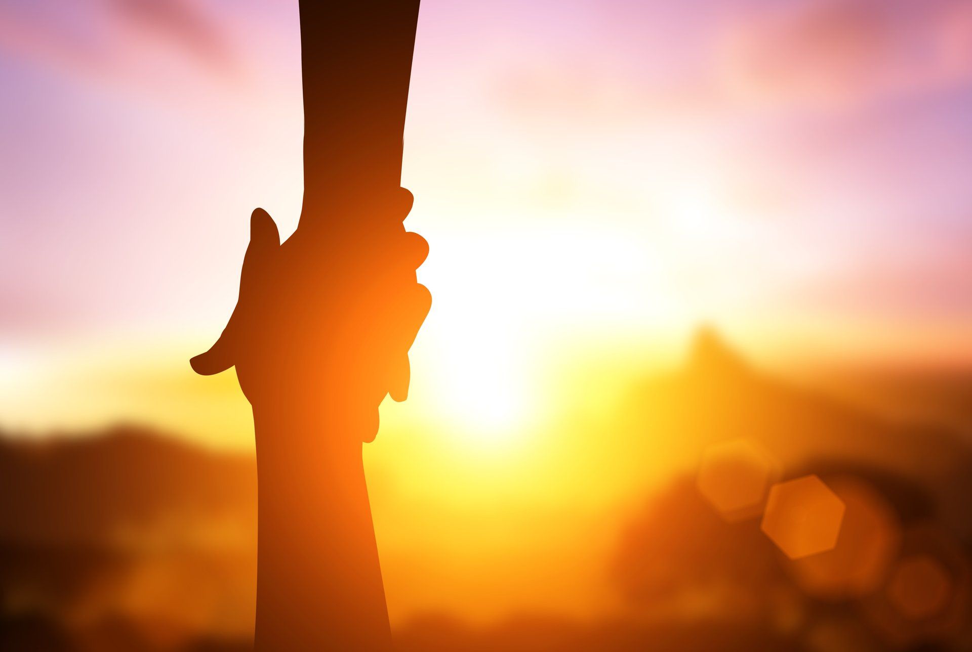 Gegen einen hellen Sonnenuntergang greifen einander schattenhafte Hände nach vorn – ein Symbol der Unterstützung.