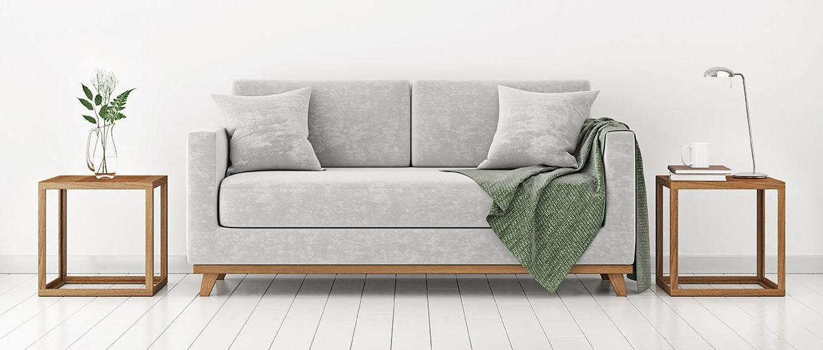 Uma sala de estar moderna com um sofá cinza, duas mesas laterais de madeira e paredes brancas.