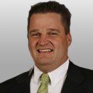 A man in a suit and tie is smiling for the camera.