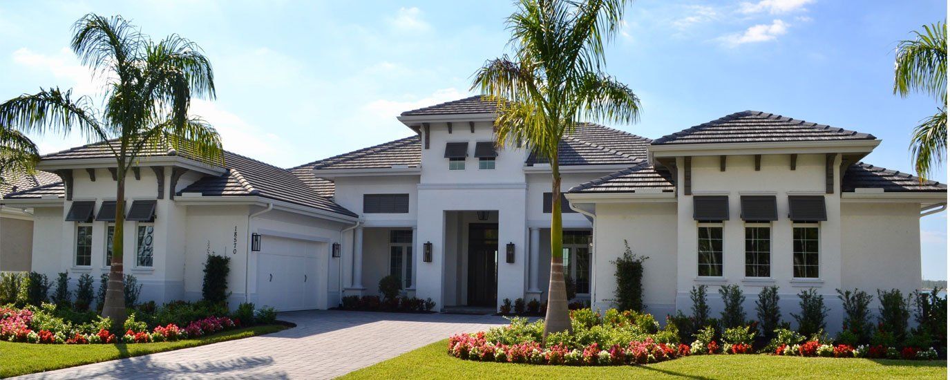A large white house with palm trees in front of it