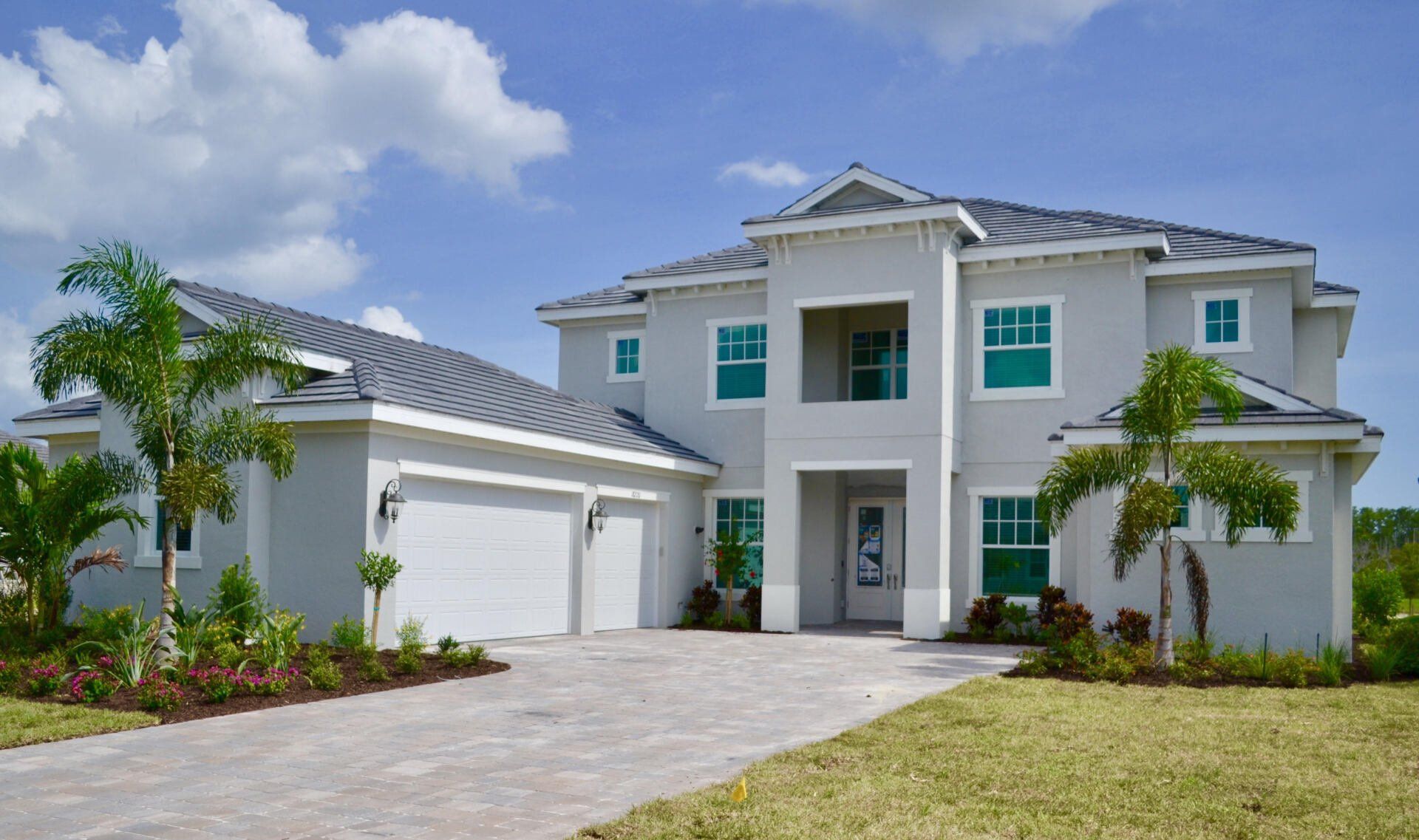 A large white house with a gray roof and green windows