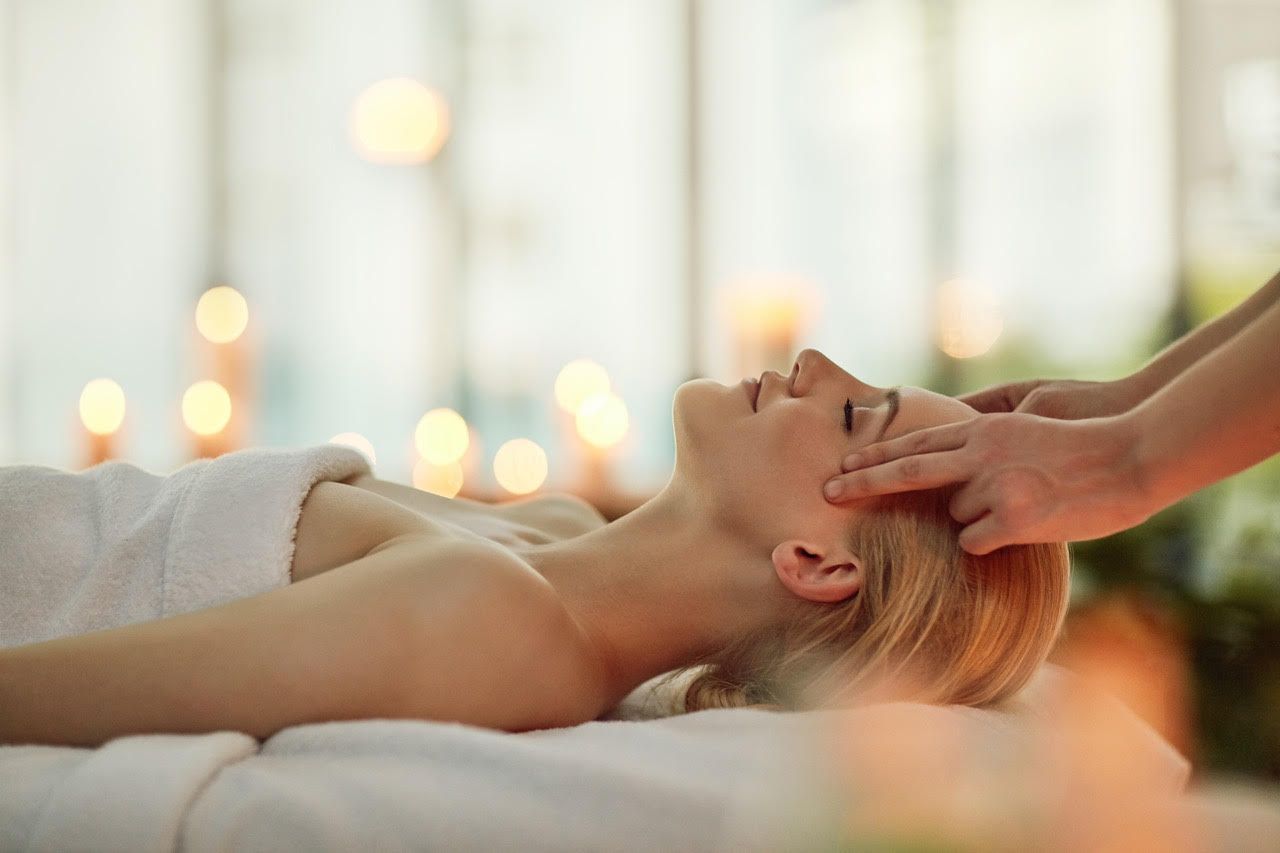 A woman is getting a head massage at a spa.