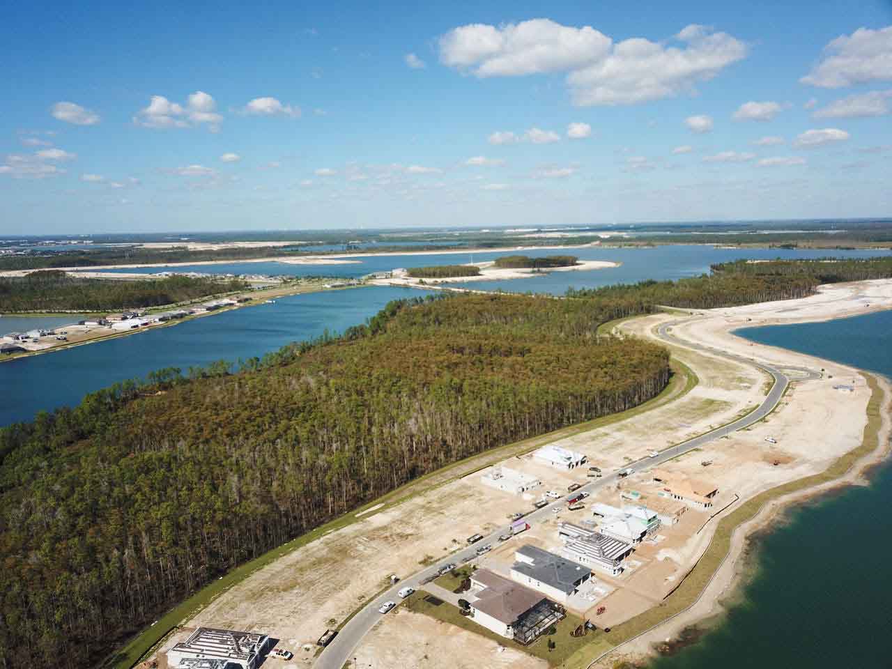 An aerial view of a lake surrounded by trees and houses.