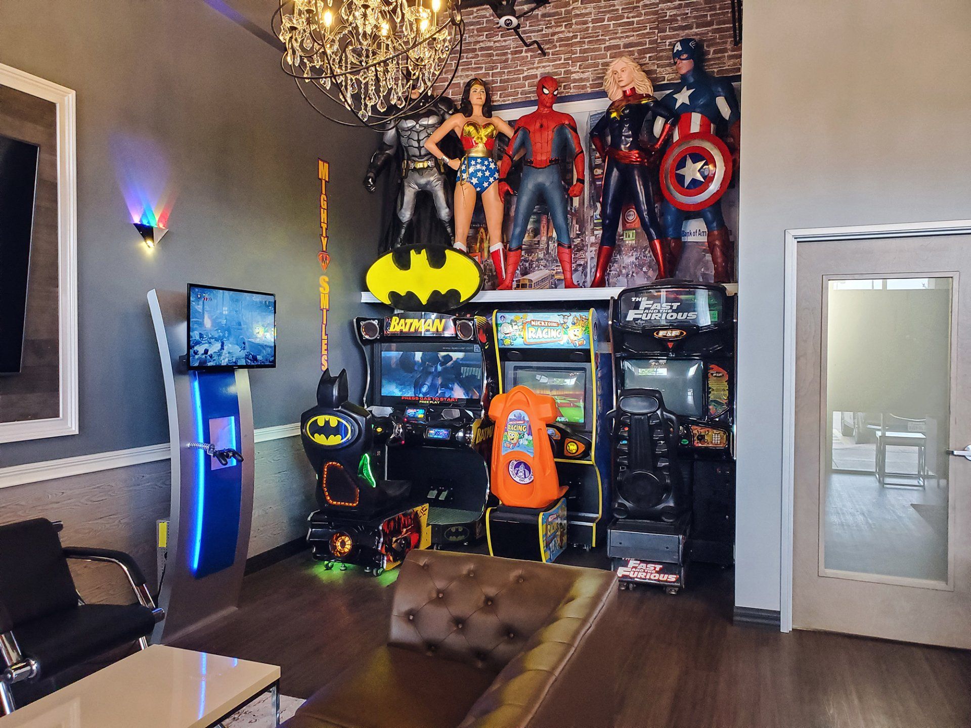 Mighty Smiles Dental, Dallas & Fort Worth. A living room filled with lots of arcade games and superhero statues.