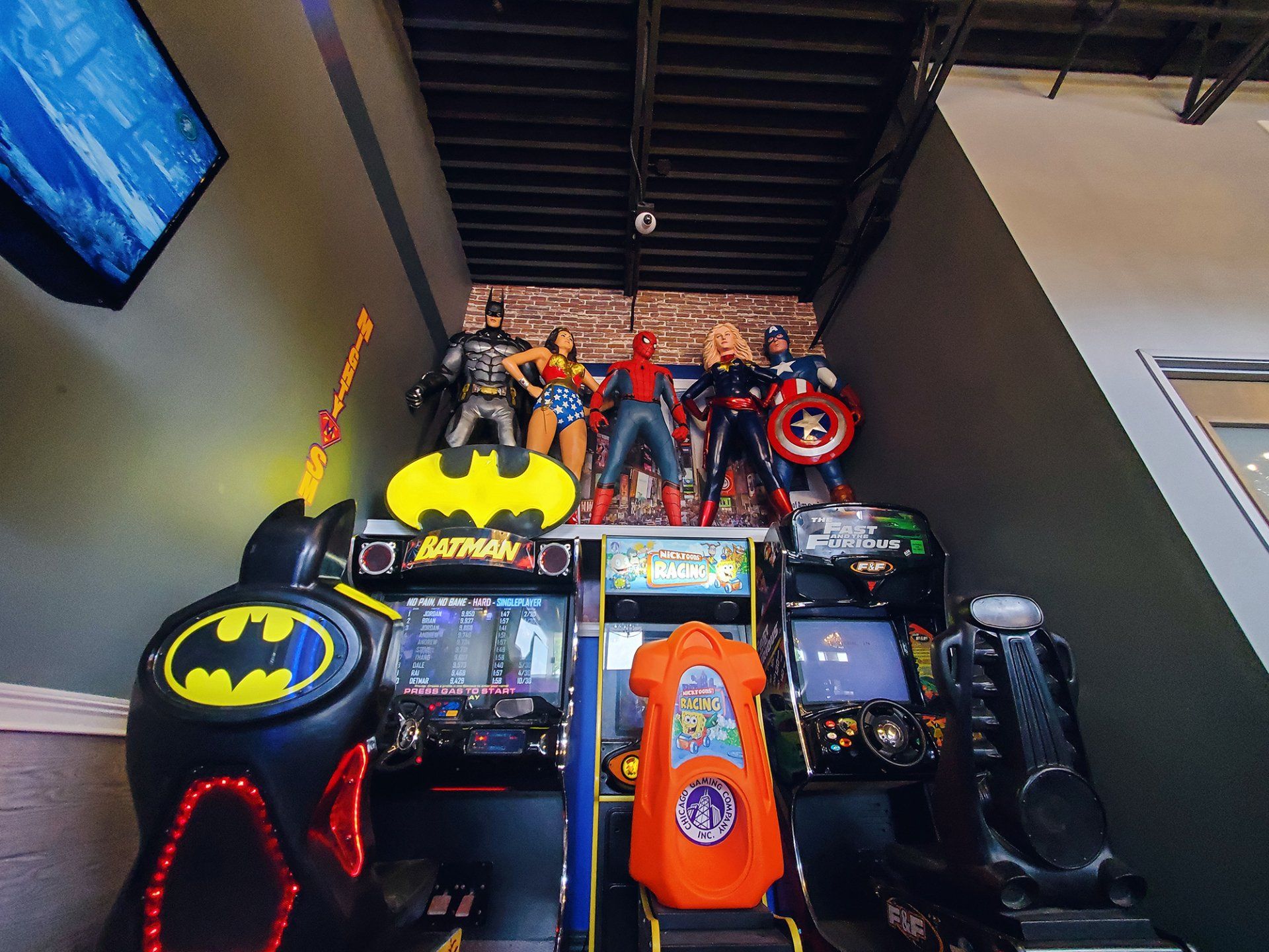 A bunch of arcade games are lined up in a room.
