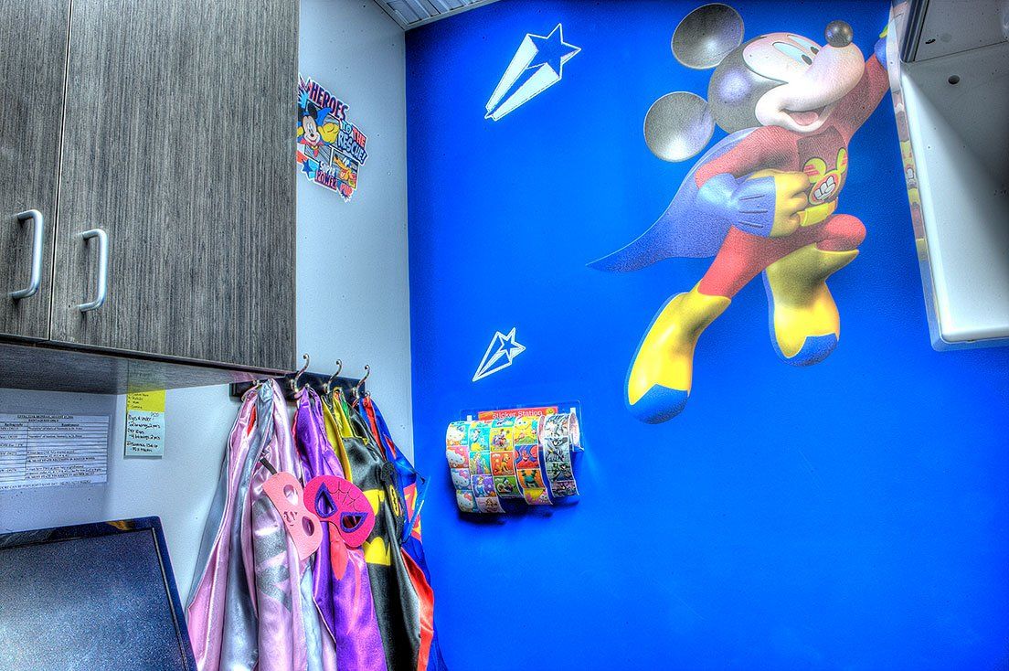 Mighty Smiles Dental, Dallas & Fort Worth. Lobby A blue wall with a picture of mickey mouse on it