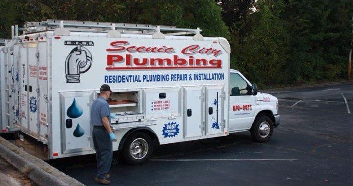 A service city plumbing truck is parked in a parking lot