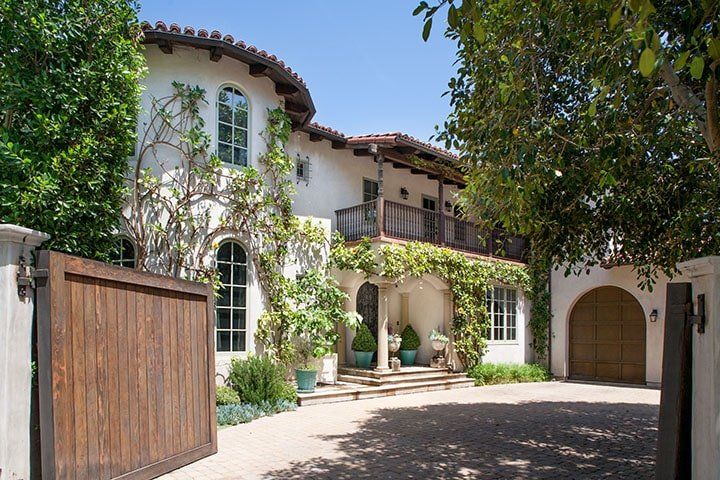A large white house with a wooden gate in front of it