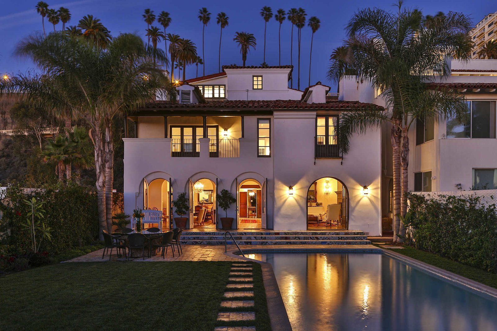 A large white house with a swimming pool in front of it