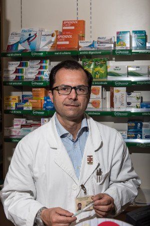 un uomo con un camice bianco in una farmacia