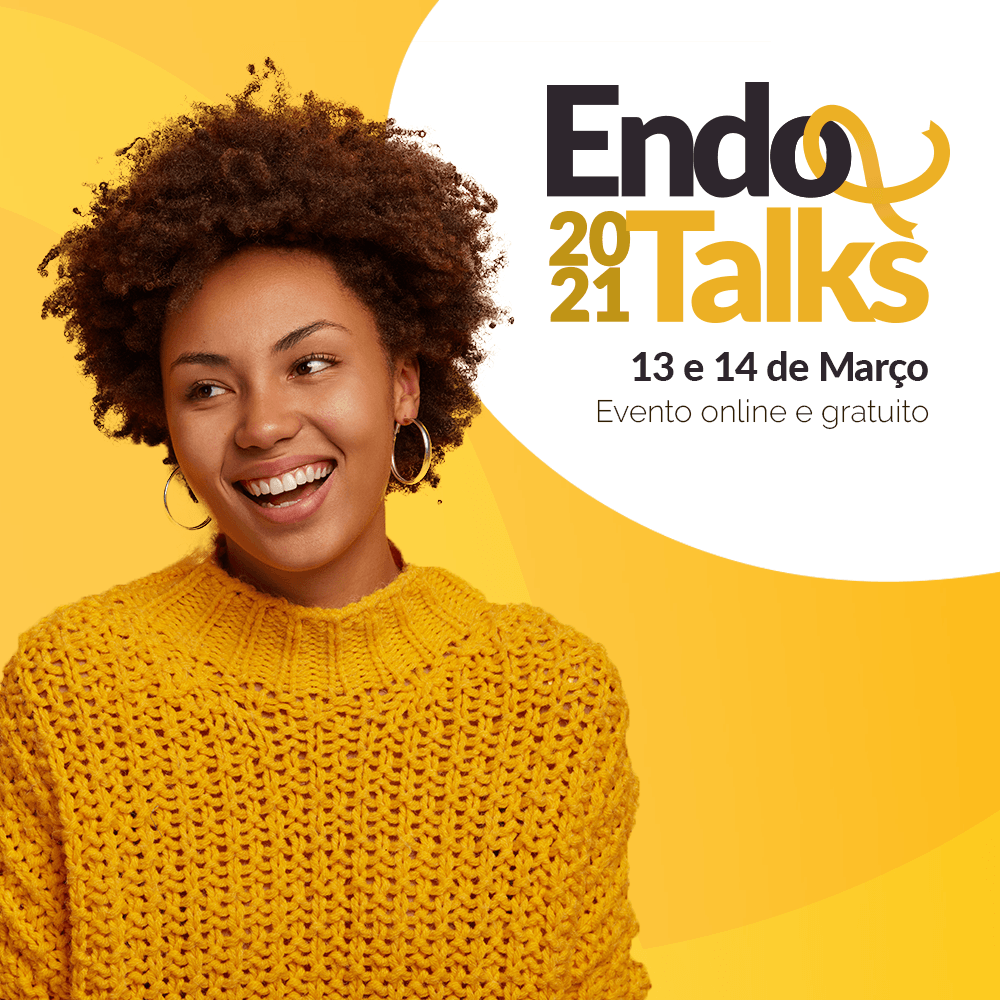 Uma mulher vestindo um suéter amarelo está sorrindo em frente a um fundo amarelo.