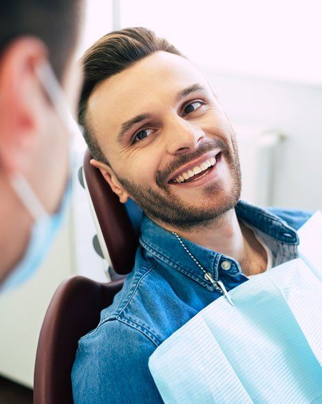 A man sitting on the dental chair — Wyoming, MI — Dental South A man sitting on the dental chair — Wyoming, MI — Dental South