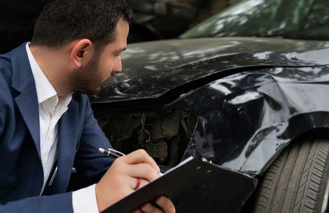 Collision Insurance — A Guy Inspecting A Wrecked Car in Gardendale, AL Collision Insurance — A Guy Inspecting A Wrecked Car in Gardendale, AL