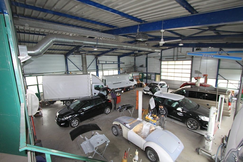 intérieur de garage avec véhicules en réparation