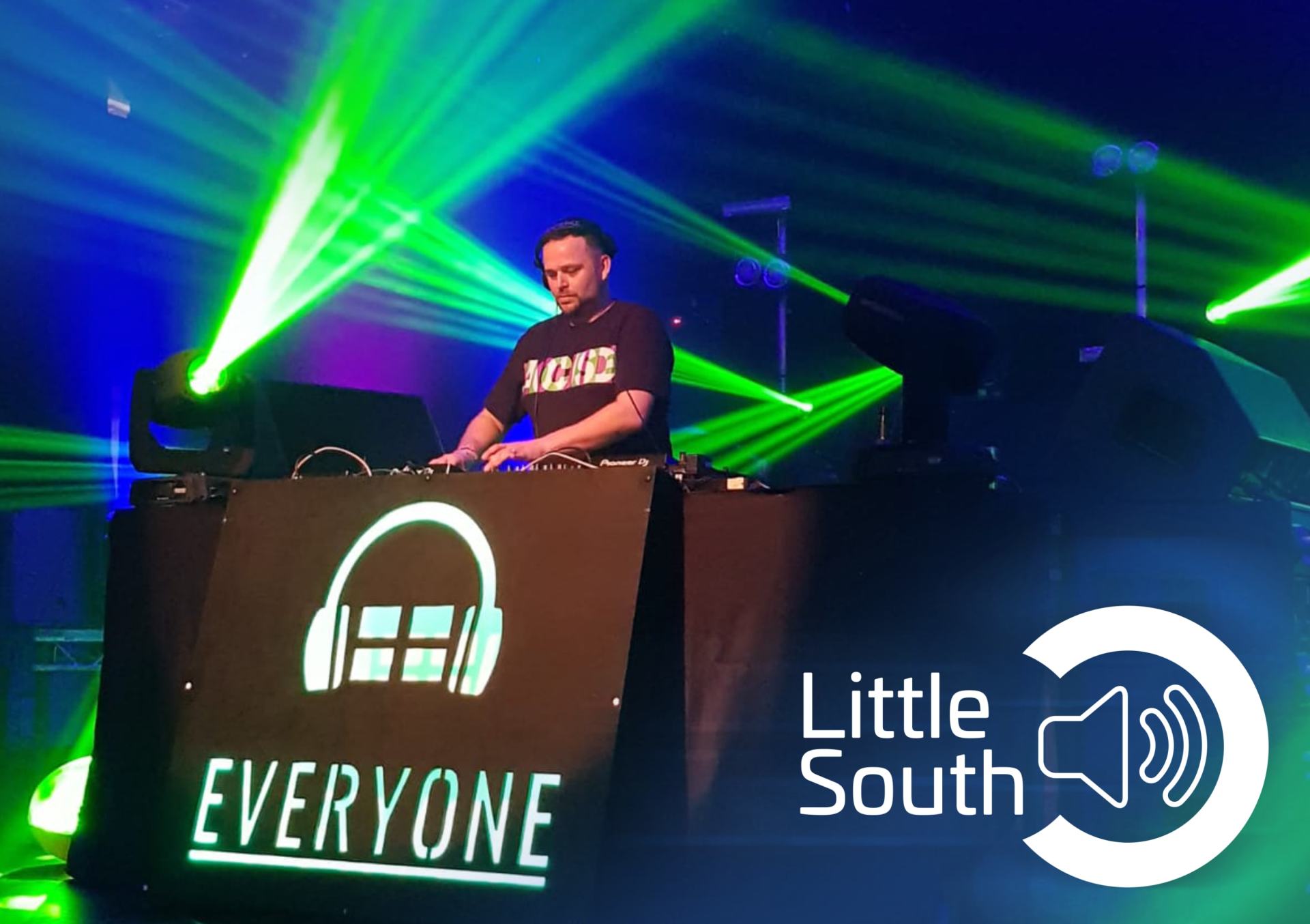 A dj playing music in front of a sign that says everyone