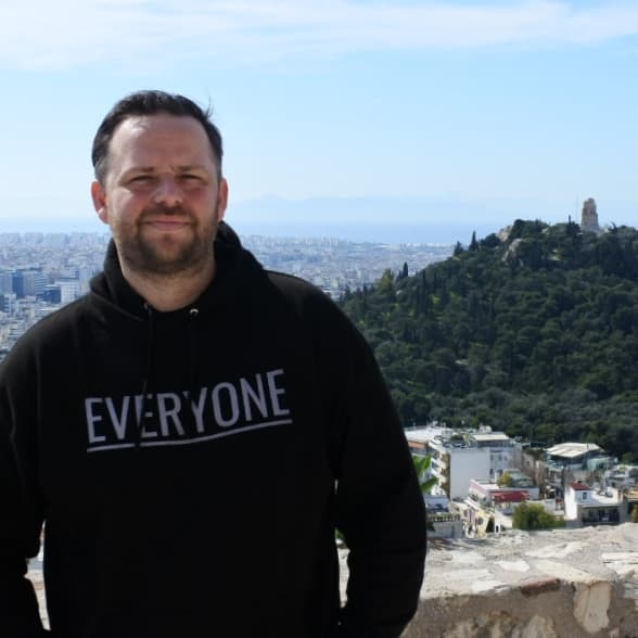 A man wearing a black sweatshirt that says everyone