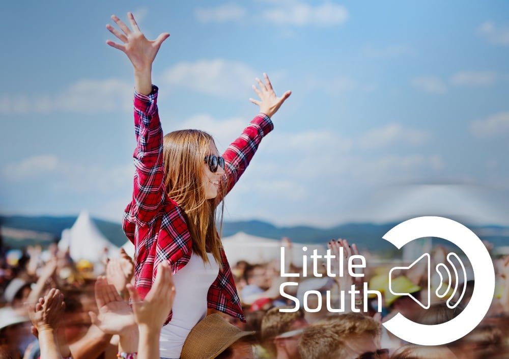 A woman is being lifted in the air at a music festival.