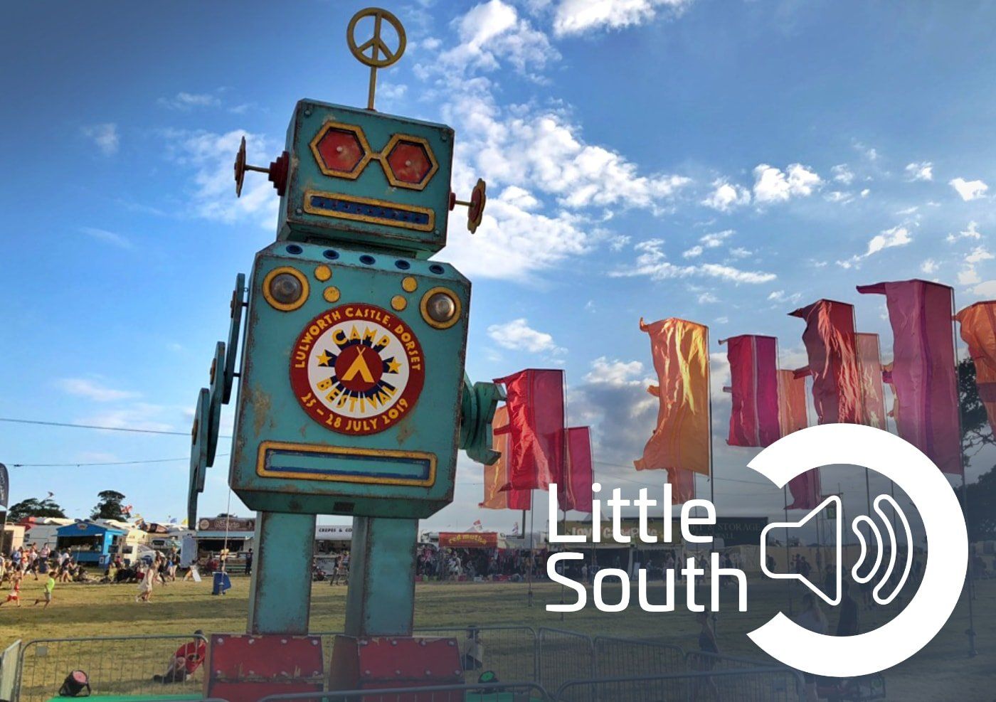 A statue of a robot with a peace sign on top of it.