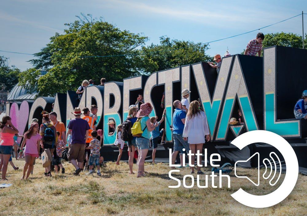 A group of people standing in front of a sign that says little south