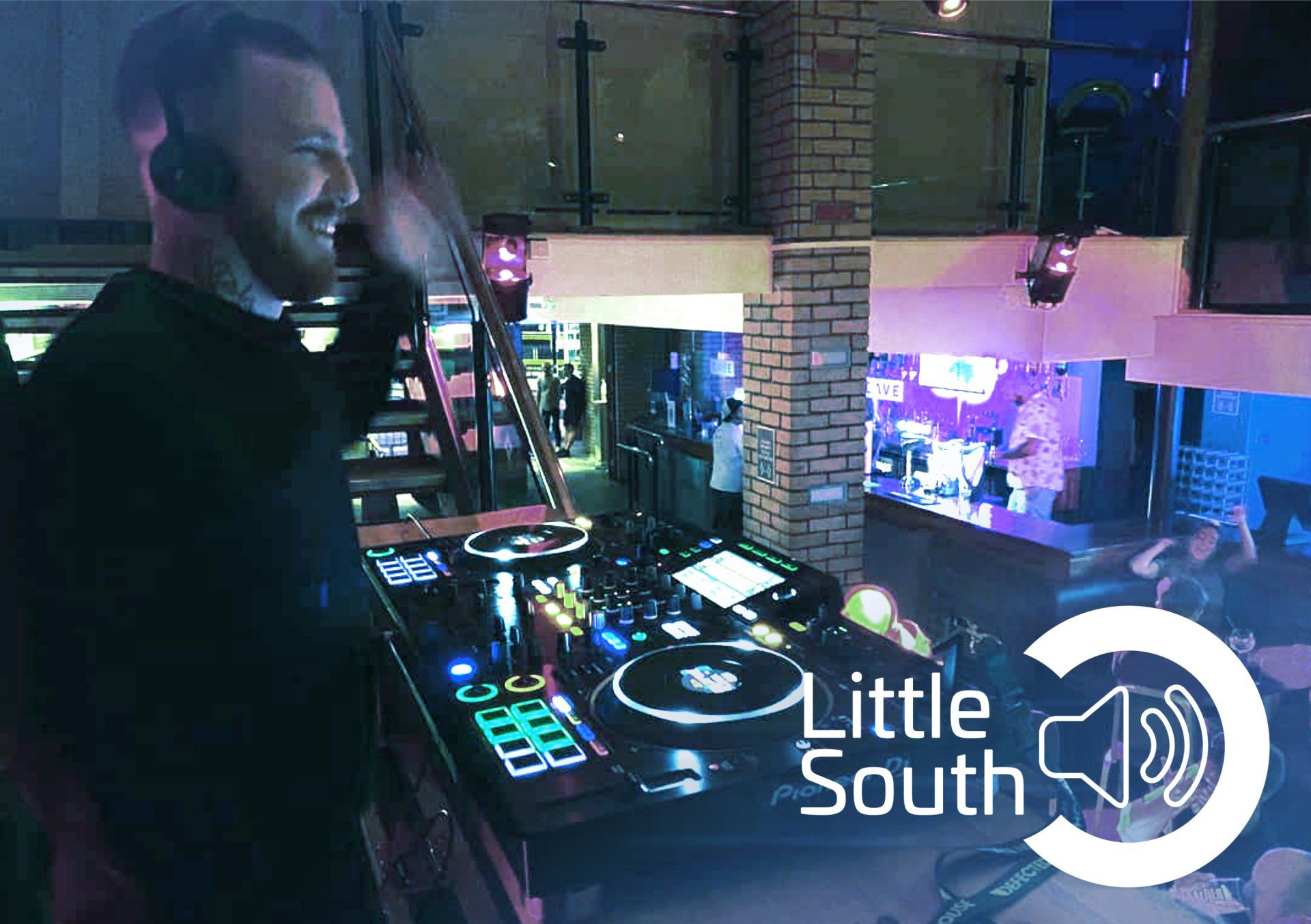A man wearing headphones is playing music in a club.