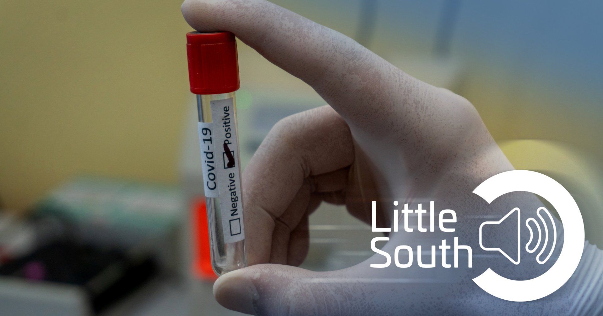 A person is holding a test tube with a label that says covid-19