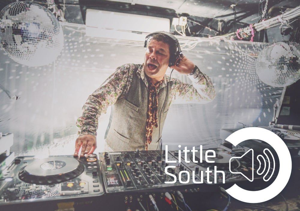 A man wearing headphones is playing music at a little south event