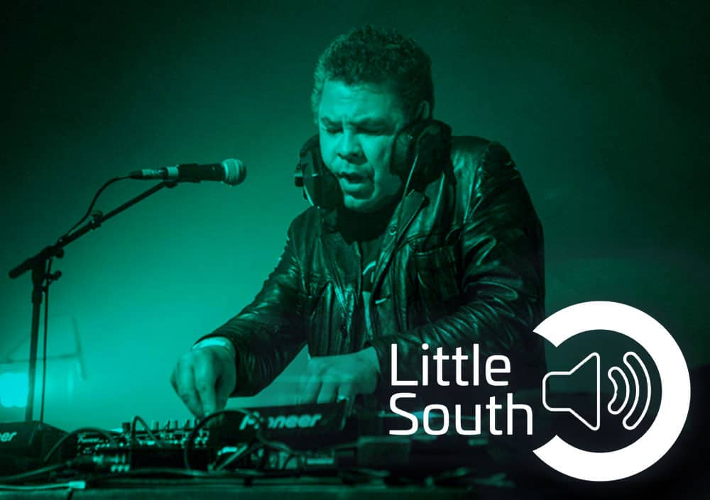 A man is playing a dj set in front of a microphone.