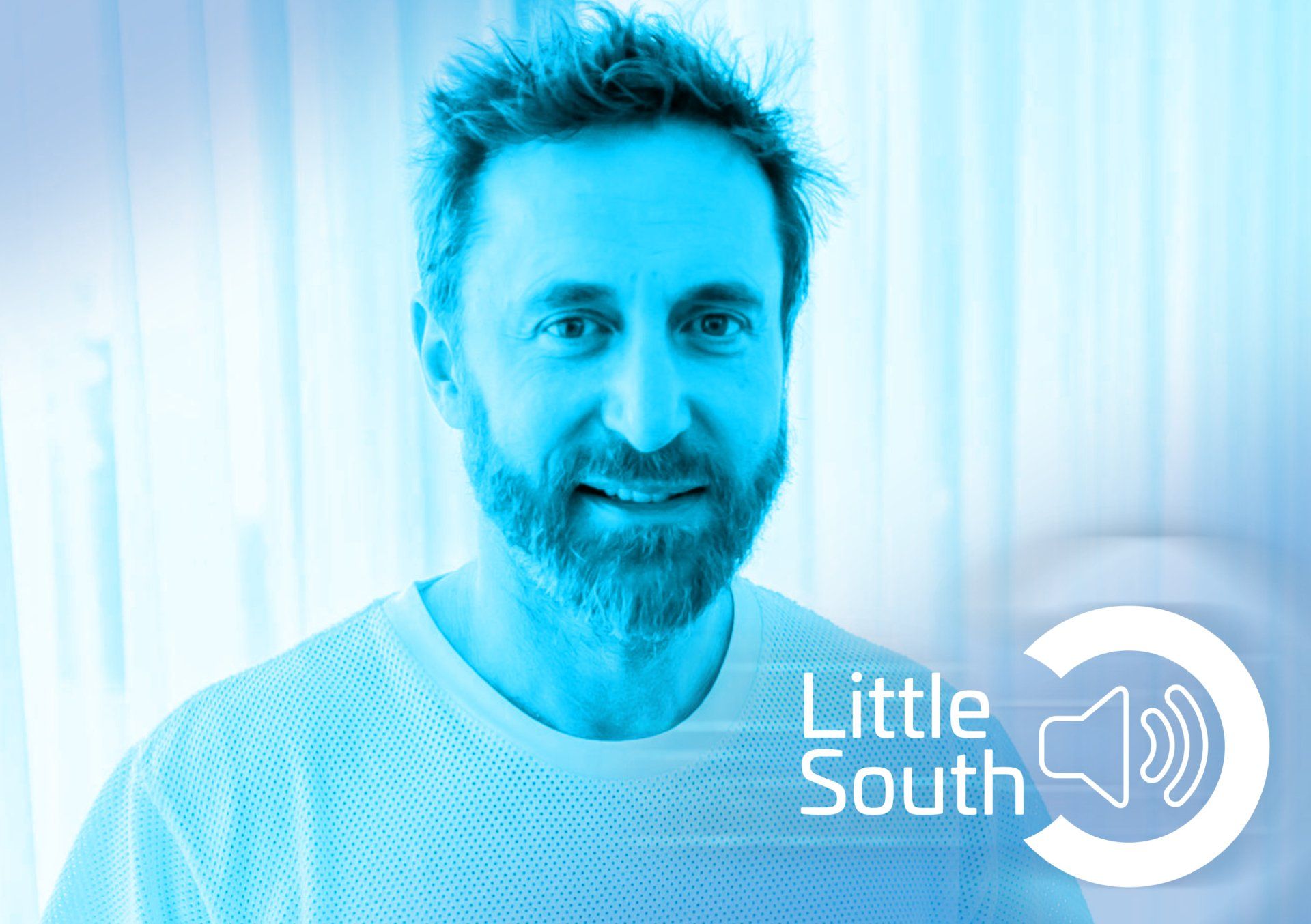 A man with a beard is wearing a blue shirt that says little south