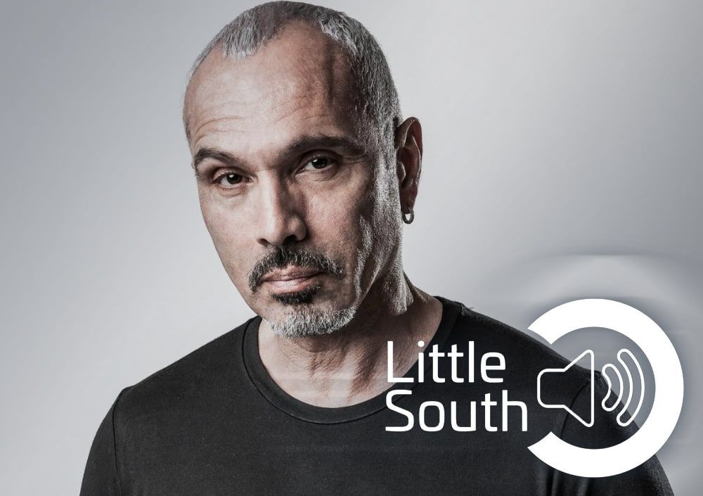 A man with a beard is wearing a little south shirt