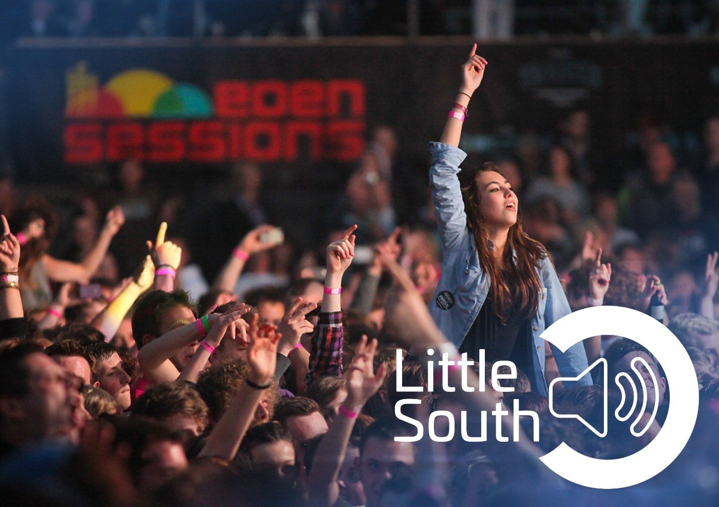 A woman is standing in front of a crowd of people at a concert.