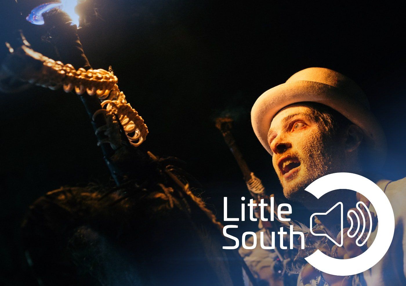 A man in a top hat is playing a saxophone in a dark room.