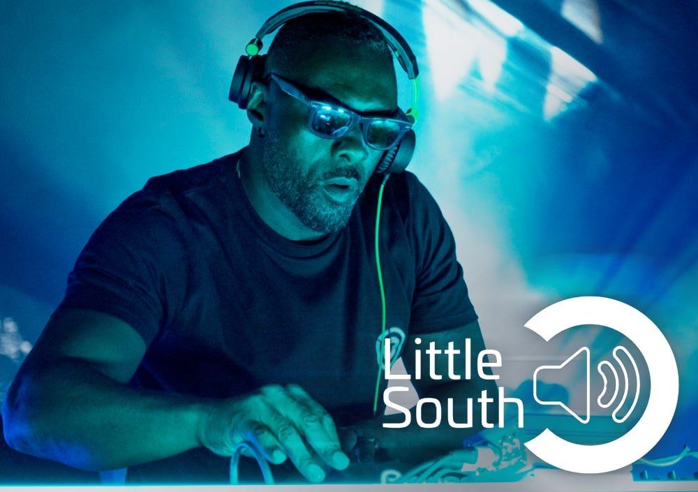 A man wearing headphones and goggles with the words little south below him