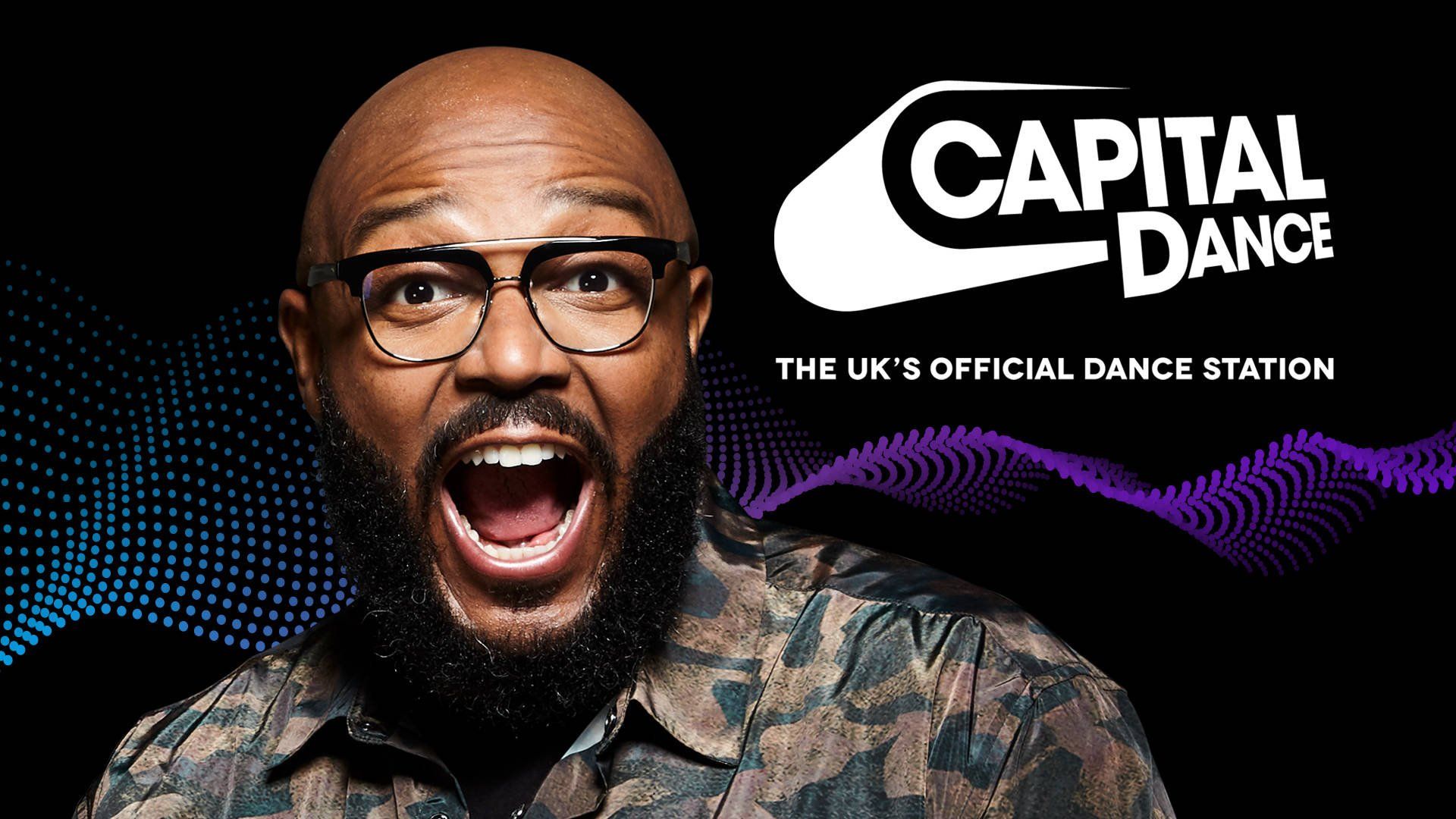 A man with glasses and a beard is standing in front of a capital dance logo.