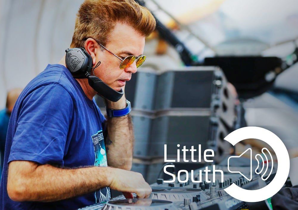 A man wearing headphones and sunglasses is playing a dj set.