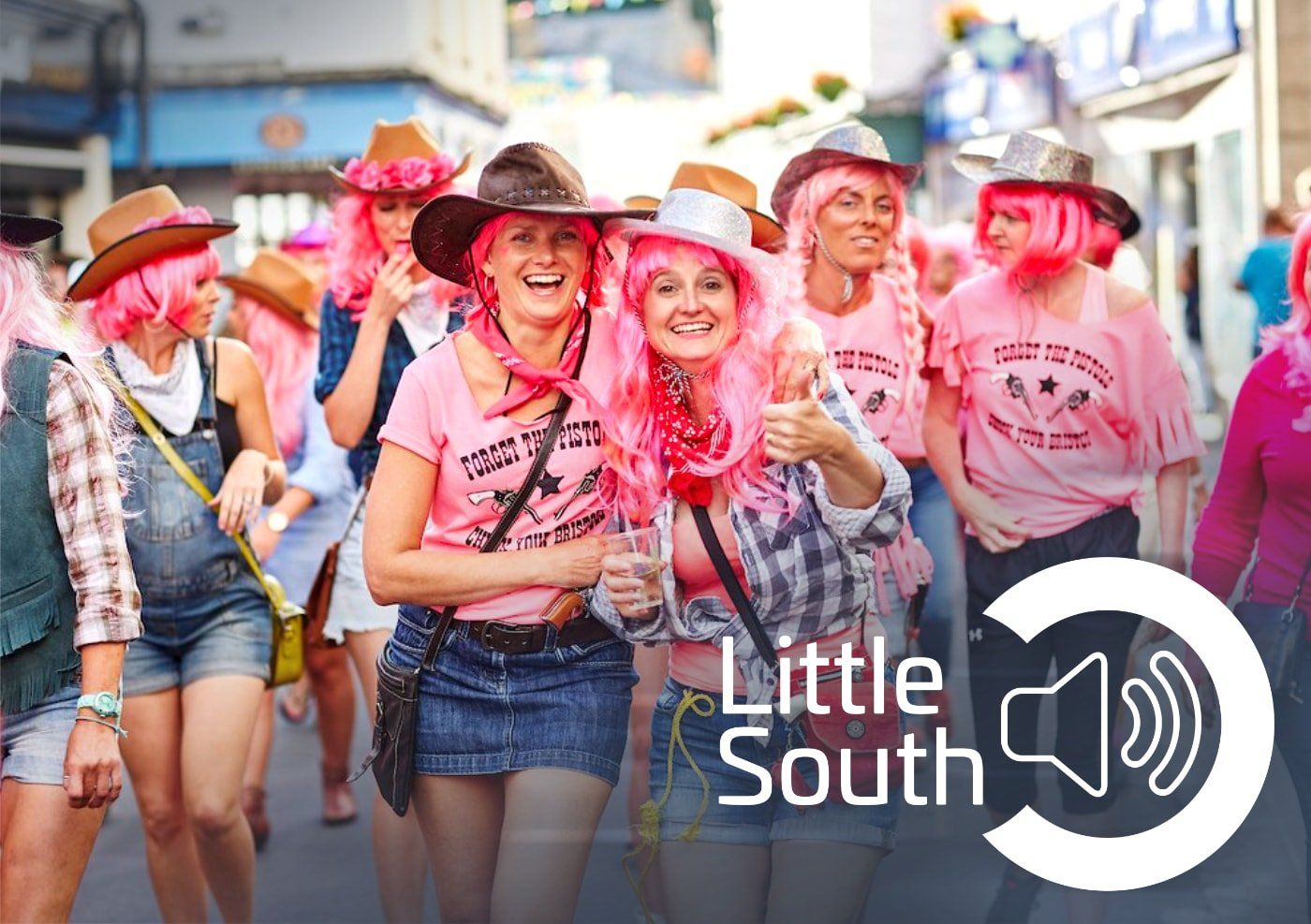 A group of women wearing pink wigs and cowboy hats are walking down a street.