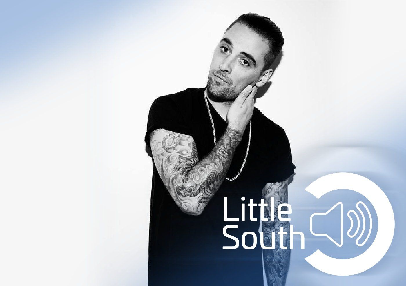 A man with tattoos is standing in front of a little south logo