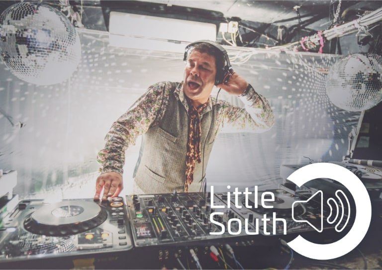 A man wearing headphones is playing music at a little south event