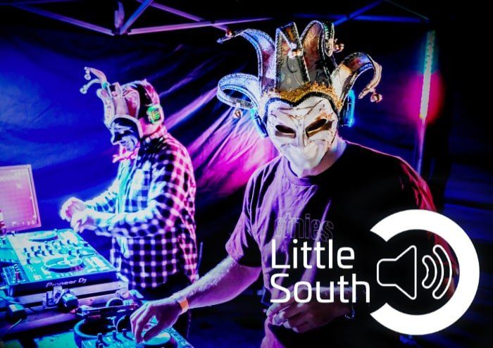 Two men wearing masks are playing music at a little south event