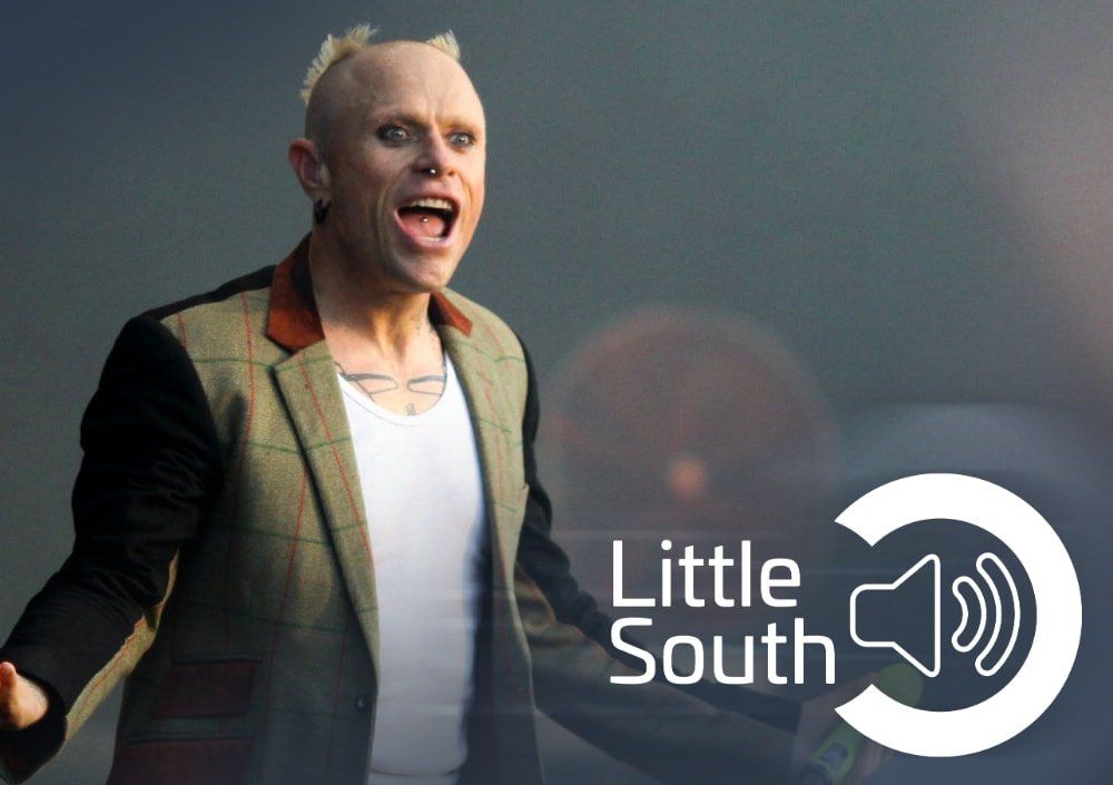 A man in a suit is standing next to a little south logo
