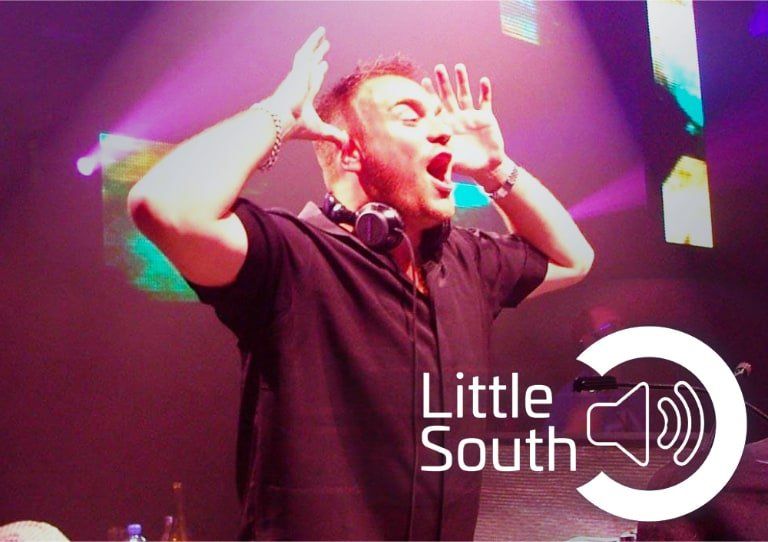A man wearing headphones on a stage with the words little south on the bottom