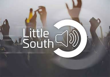 A group of people are standing in front of a sign that says little south.
