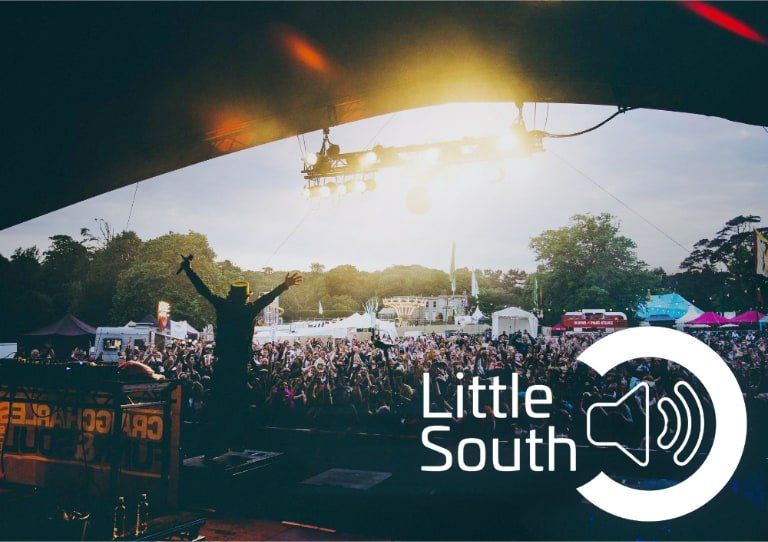 A man is jumping in the air in front of a crowd at a little south festival.