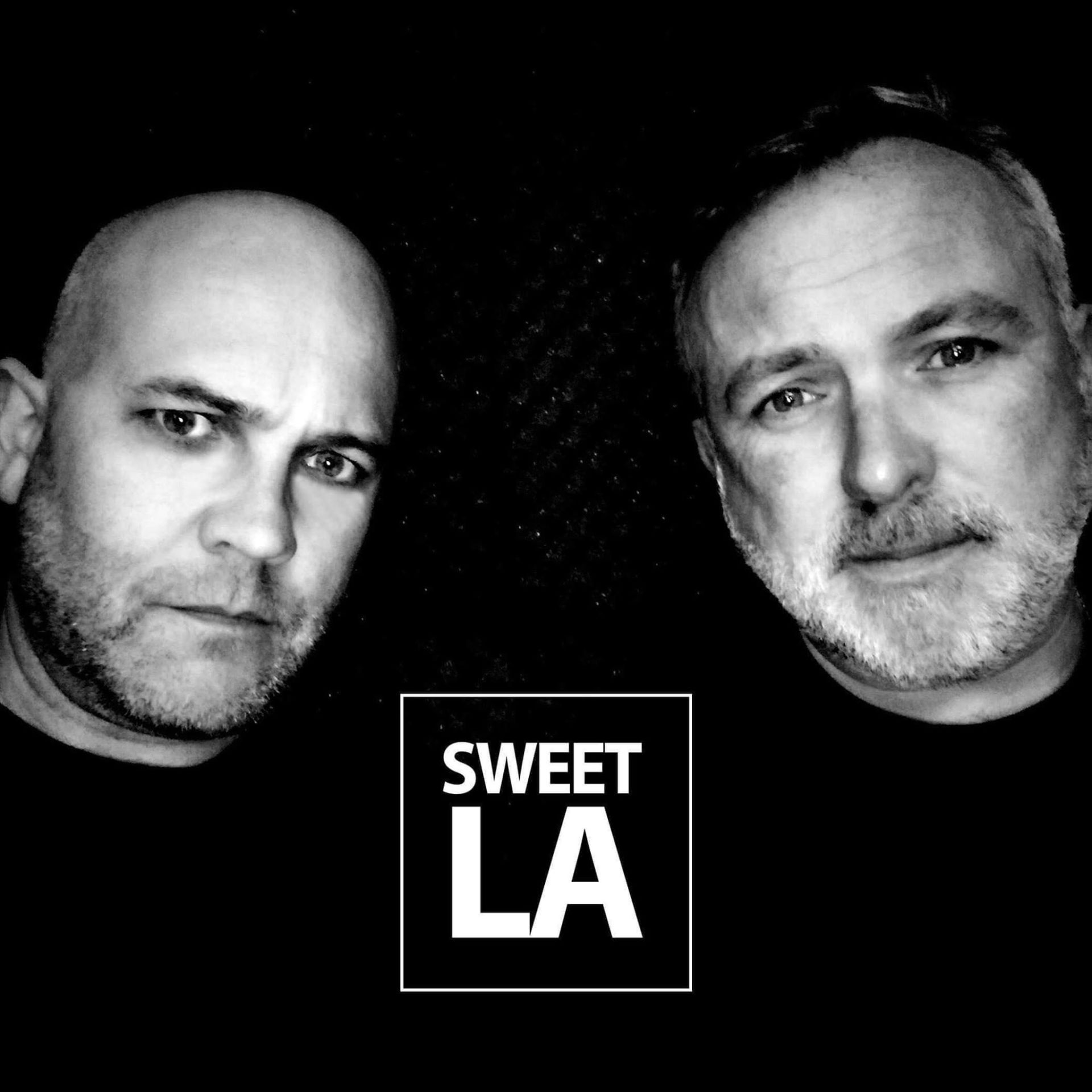 Two men are standing next to each other in front of a sign that says sweet la.