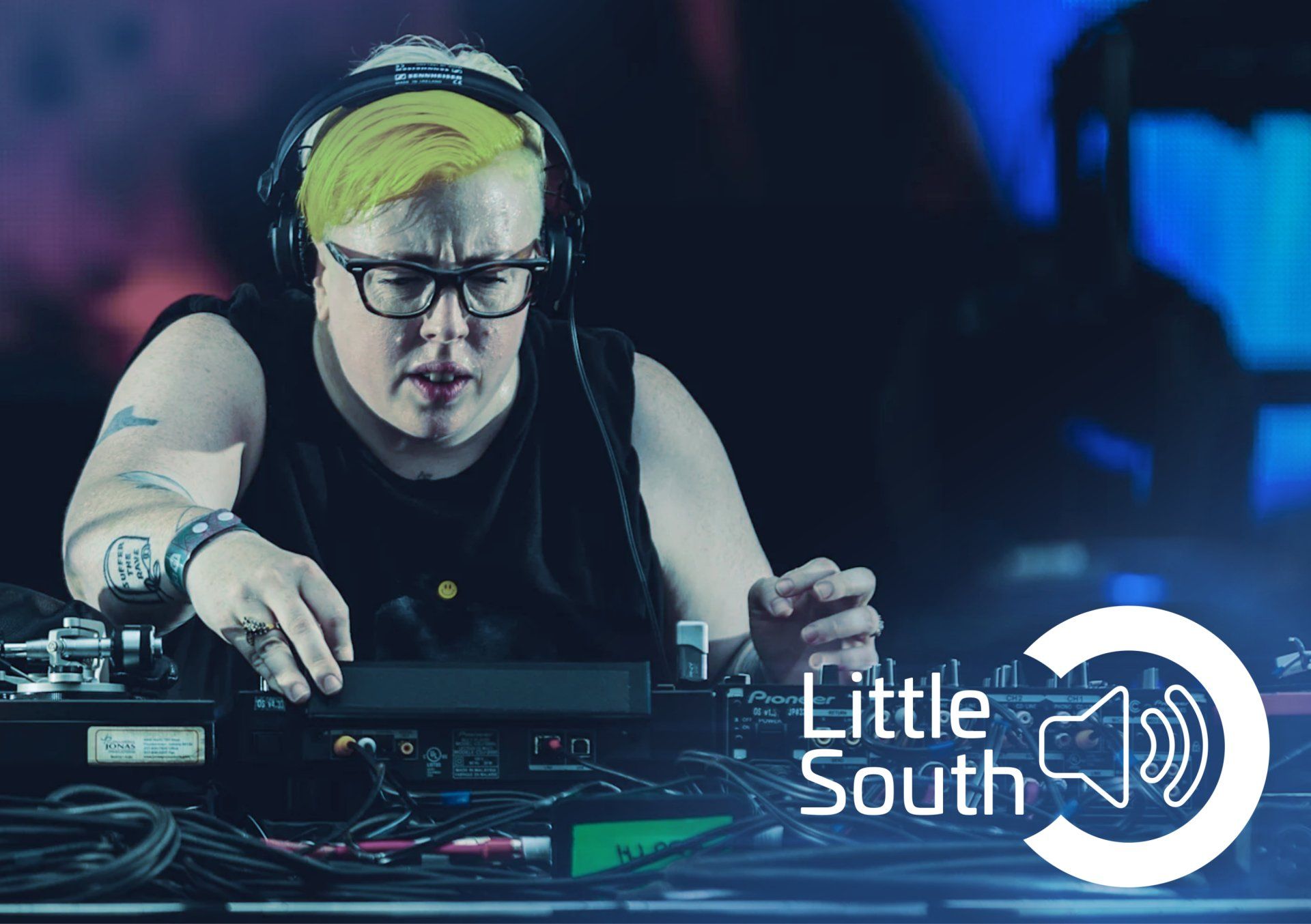 A woman wearing headphones and glasses is playing a dj set.